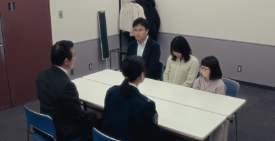 警察が家族に説明をしているシーン