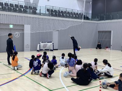 子どもたちがコーチの手本を見ている様子