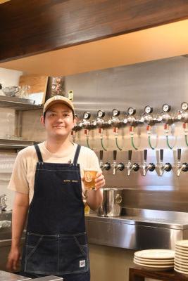 ビールを片手に持つ平良さんの写真