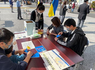 折り鶴を折る市民の画像