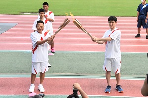 聖火ランナーのトーチキス（松田さんから松木さんへ）の写真