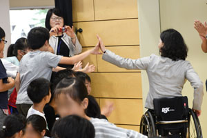 ハイタッチするマセソン美季氏と児童の写真