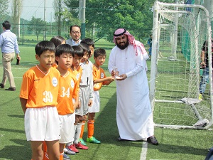 優勝トロフィーを受け取る小学生の選手の写真