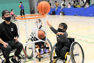 車いすバスケットボールでシュートを入れようとしてる子どもの写真