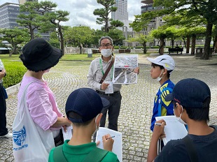 ガイドさんの話を聞く子ども達の写真