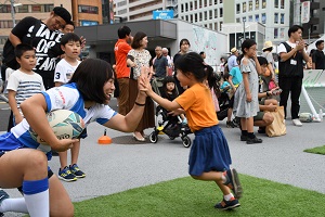 選手とハイタッチする女の子の写真