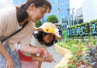 子どもとお母さんが楽しそうに花を見ている写真