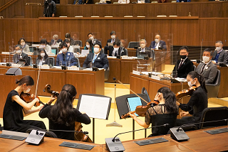 演奏を聞く議会出席者の写真