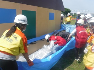 住宅浸水防止工法で水のうをブルーシートで覆う様子