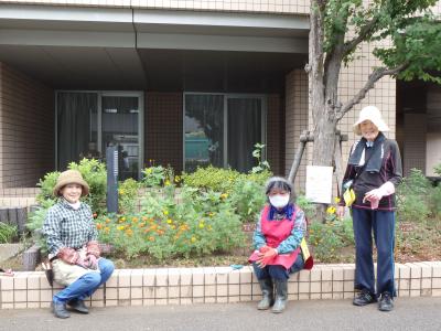 花壇の前に立つボランティアの写真